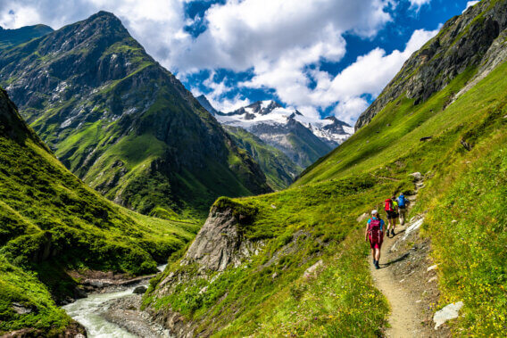 Hiking Group In Valley Of Umbalfaelle On Grossvenediger With View To Mountain Roetspitze In Nationalpark Hohe Tauern In Tirol In Austria